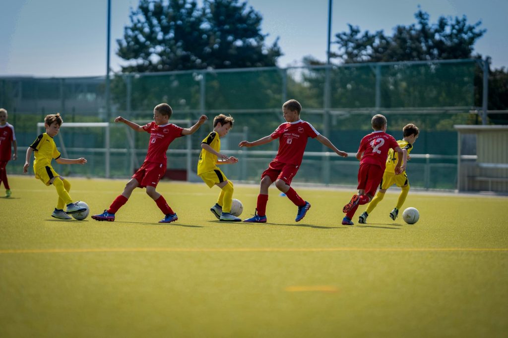 groupe d'hommes jouant au football pendant la journée